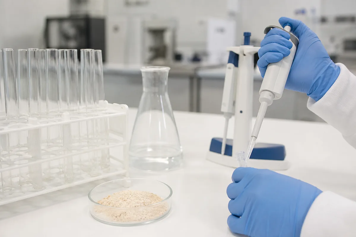 Paillasse de laboratoire avec verrerie et coupelle de poudre claire analysée
