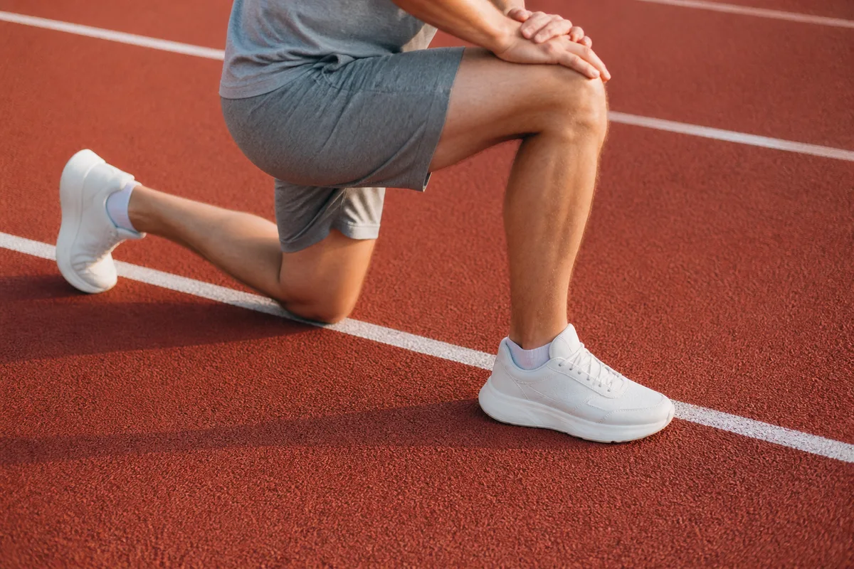 Jambes et chaussures de running en talons-fesses sur un bitume humide au petit matin